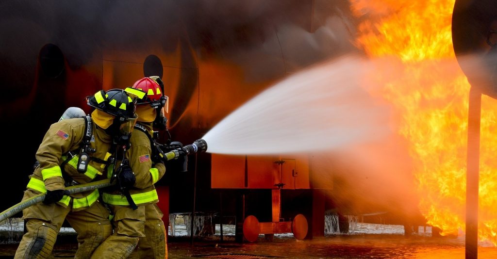 Brannmenn slukker brann. Store flammer